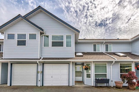 A two-story house with a garage and a covered patio.
